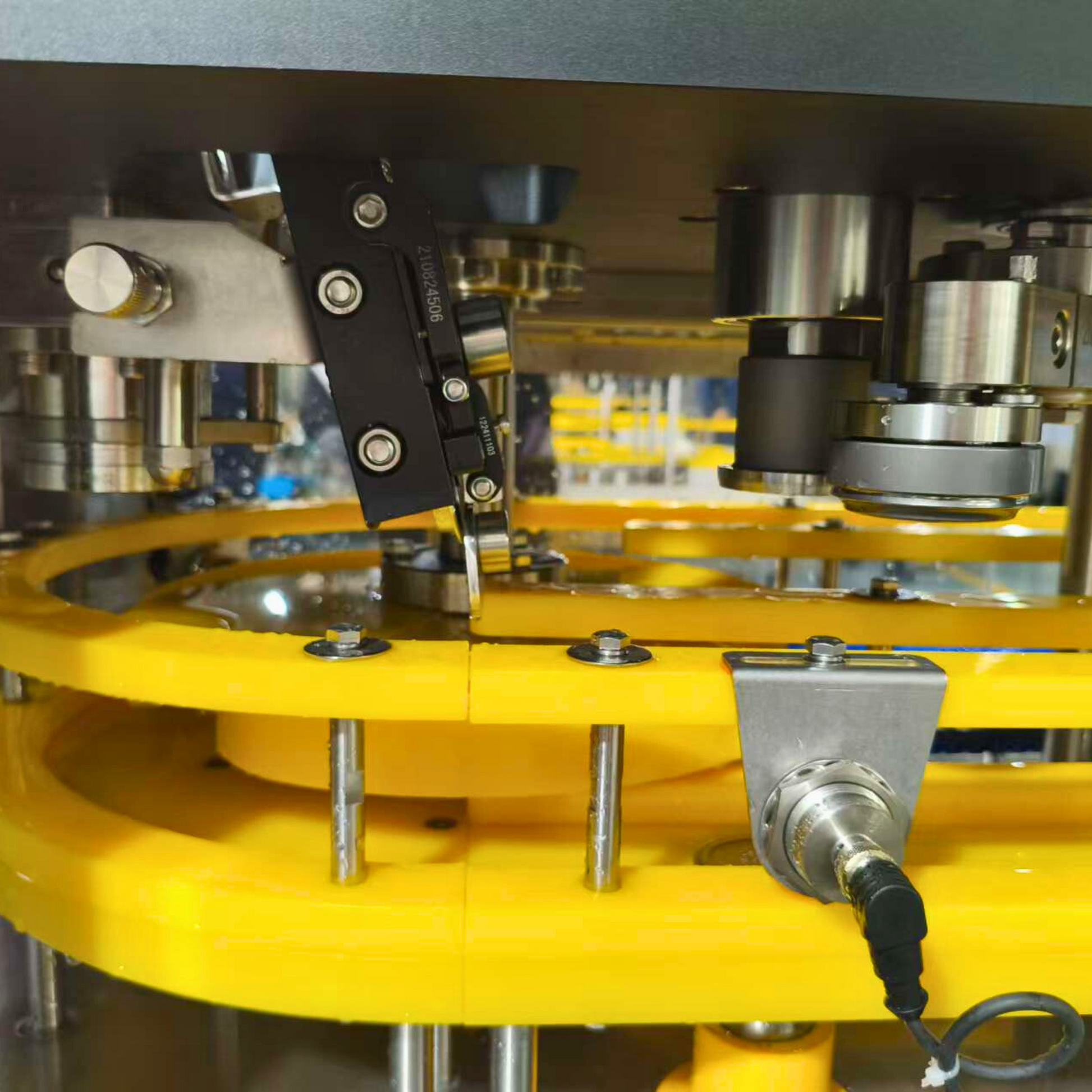 Close-up view of a 1-1 canning machine, showcasing the detailed components of the filling and sealing mechanism, including precision-engineered rollers, sensors, and guiding tracks for efficient beverage packaging.