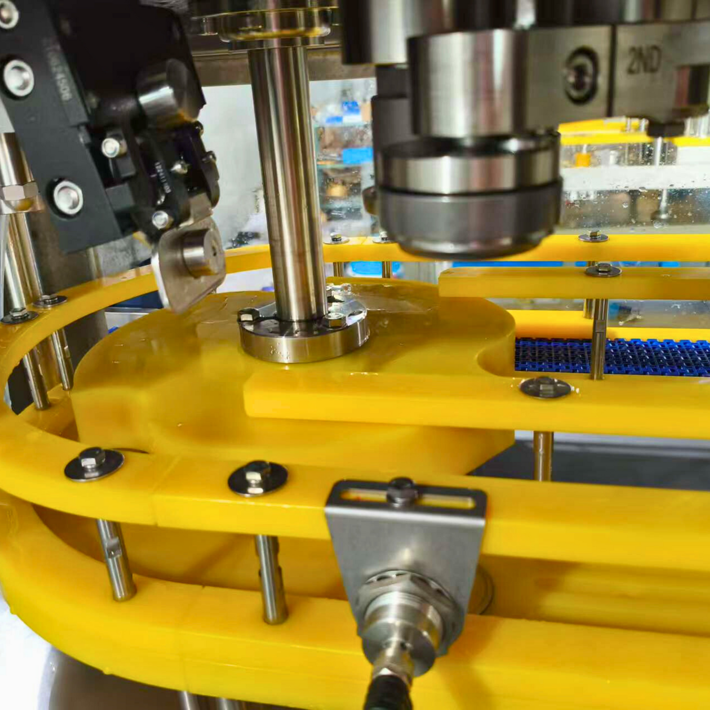 Close-up view of a 1-1 canning machine, showcasing the detailed components of the filling and sealing mechanism, including precision-engineered rollers, sensors, and guiding tracks for efficient beverage packaging.